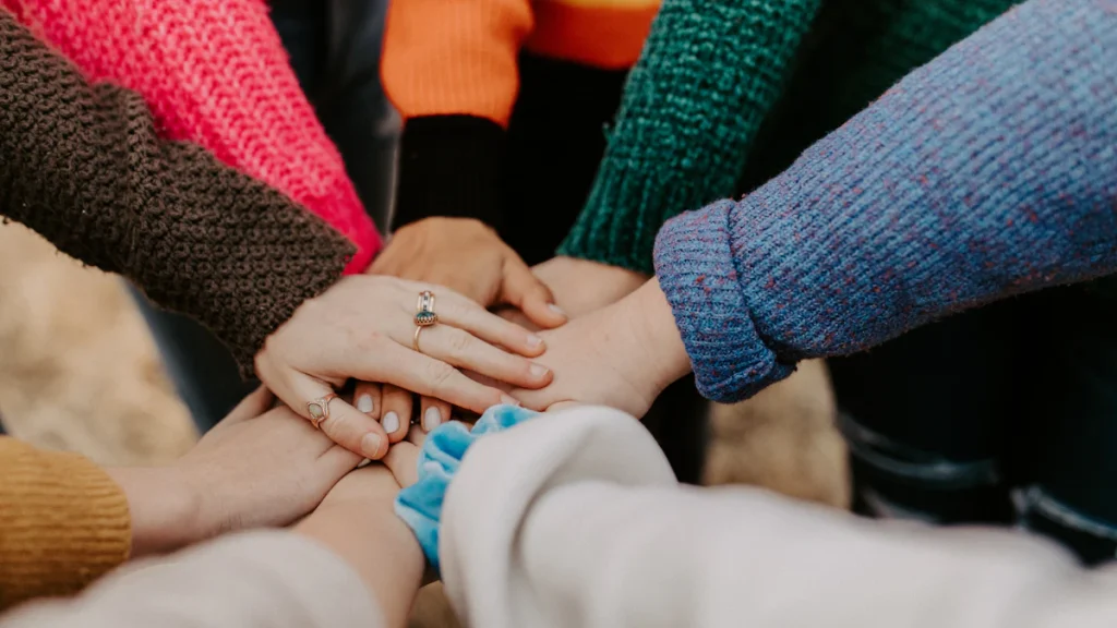 Groupe empilant les mains