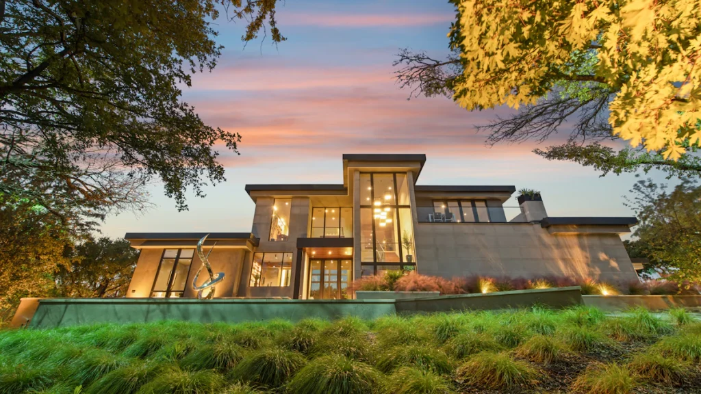 Maison moderne avec de grandes fenêtres au crépuscule